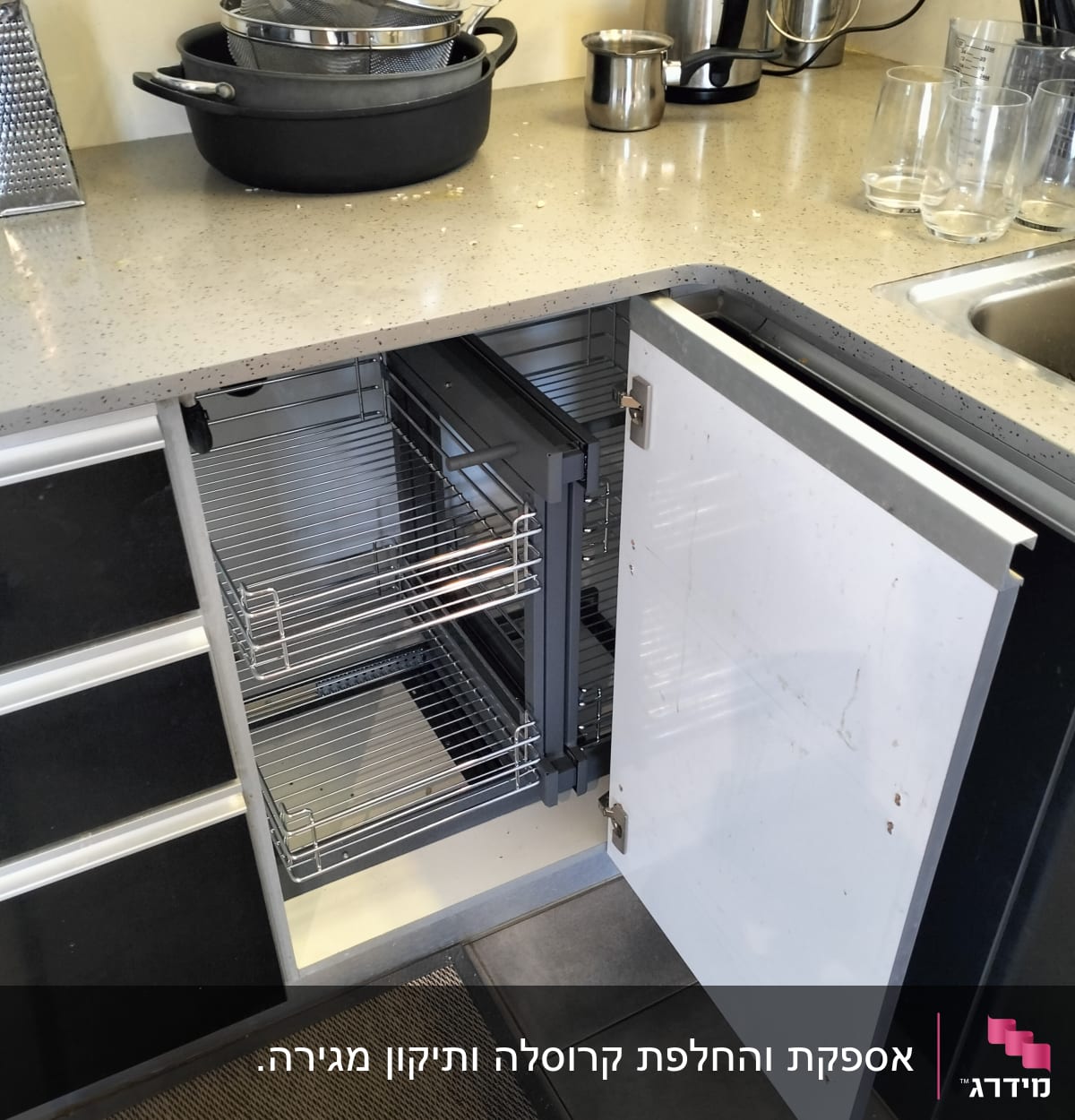 ארון מטבח פתוח עם מדפים נשלפים וסירים על השיש
